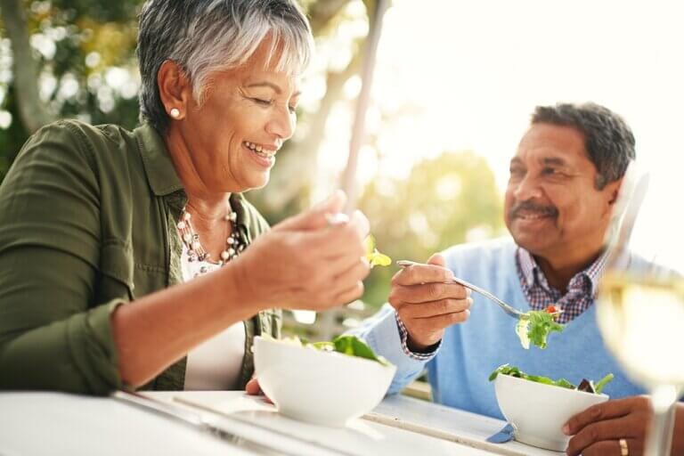 Joyful seniors enjoying a balanced, nutritious meal at home, showcasing the benefits of healthy eating for seniors