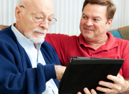 A man and his father discuss a reverse mortgage to pay for senior care.