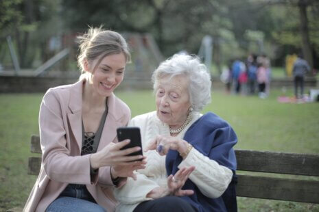 A woman provides companionship to an elderly woman
