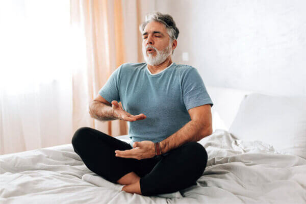man with COPD doing yoga in bed
