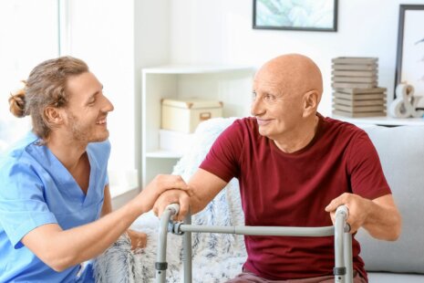 Elderly man being assisted by caregiver paid for by long term care insurance