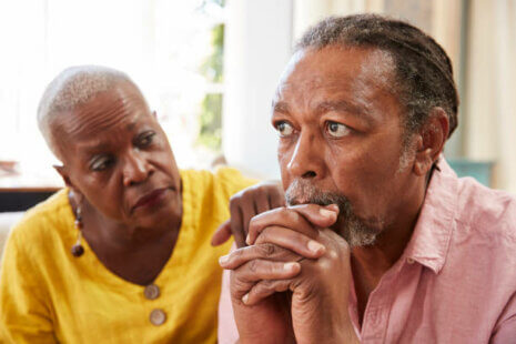 Senior Woman Comforting Grieving Elderly Man At Home