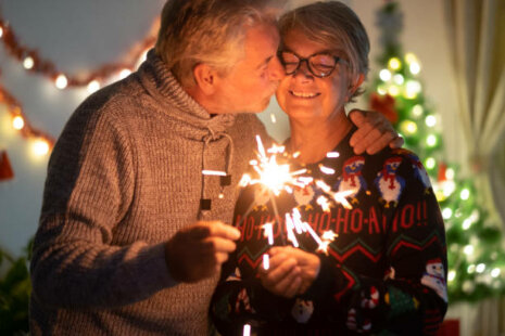 An affectionate kiss between elderly wife and husband who celebrate New Year's Eve.