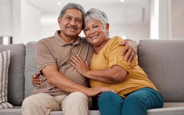 elderly couple on the couch happy they have long-term care insurance