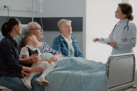 Family speaking with a doctor during an elderly hospital stay.
