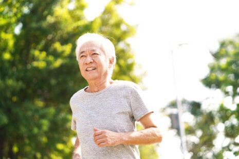 Senior asian man running outside to prevent vitamin D deficiency in the elderly.