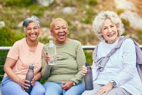 Elderly women drinking water to promote senior hydration during summer months