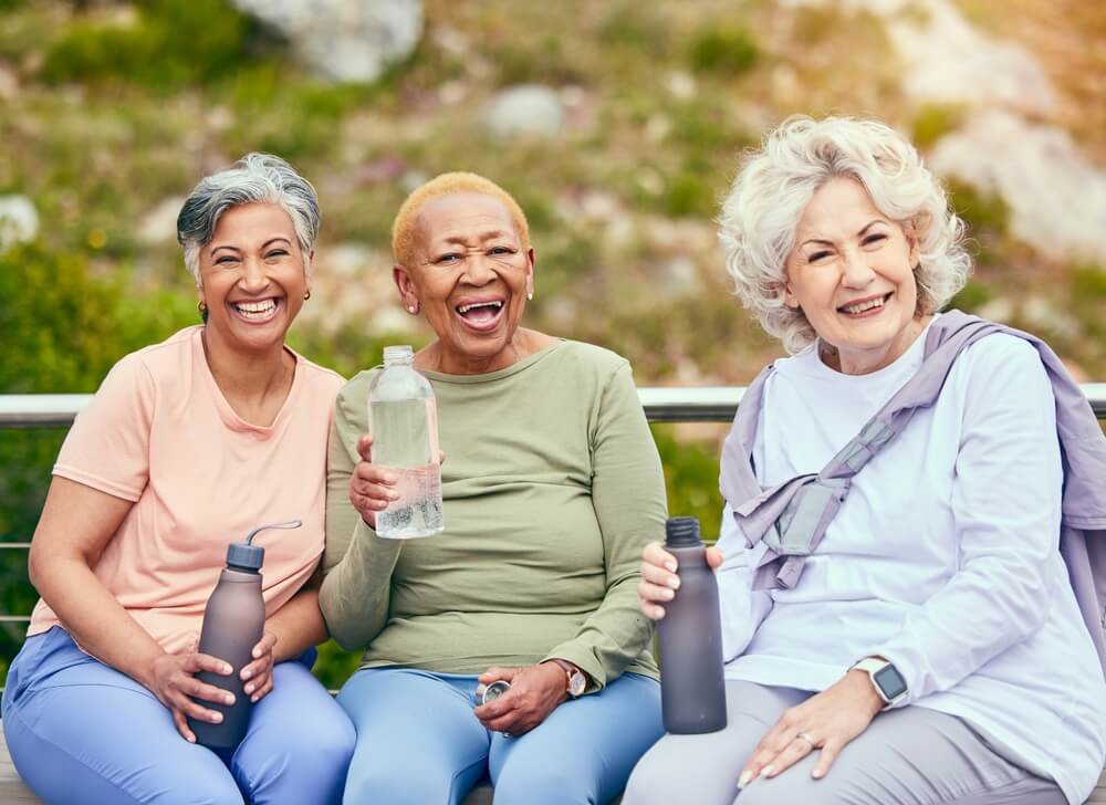 Elderly women drinking water to promote senior hydration during summer months