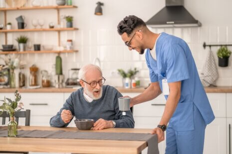 Elderly man receiving in-home senior care from a professional caregiver.