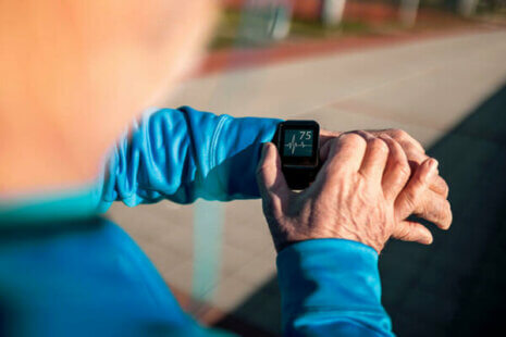 senior checking heart rate on watch monitor