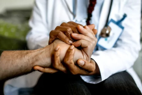 Doctor holding hands with a patient to help consider hospice.