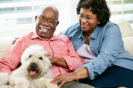 Seniors with their dog, symbolizing the companionship and happiness that pets bring to the lives of the seniors.