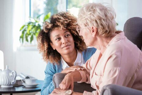 A compassionate caregiver attentively listening to an elderly person with dementia, signifying the depth of care and understanding required in dementia support.