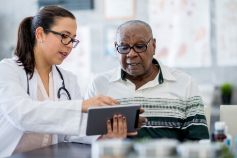 A senior couple consulting with a healthcare professional, embodying the journey of navigating healthcare in their senior years.