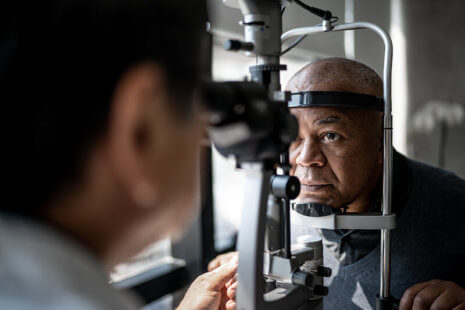 A man gets his eyes checked by an optician to prevent diabetic eye disease.