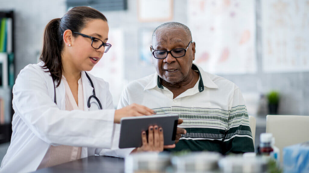 A senior couple consulting with a healthcare professional, embodying the journey of navigating healthcare in their senior years.