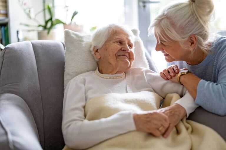 Senior and caregiver sharing laughter during companionship care session, showing how companionship care for seniors improves emotional health.