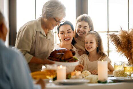 Family gathered around a Thanksgiving table, making the most of Thanksgiving with senior loved ones.