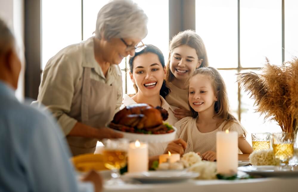 Family gathered around a Thanksgiving table, making the most of Thanksgiving with senior loved ones.