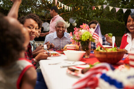 Senior woman smiling with family during Fourth of July celebration outdoors