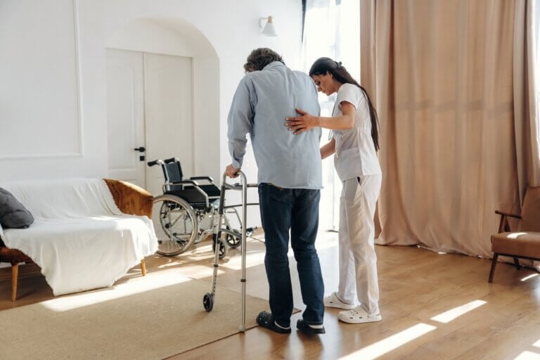 caregiver helping elderly parent settle in at home after going home after a hospital stay